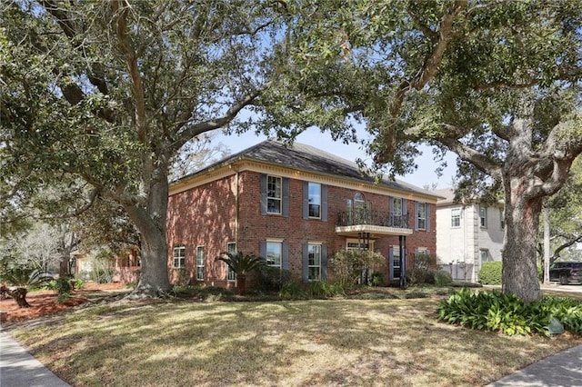 view of front facade featuring a front lawn and a balcony