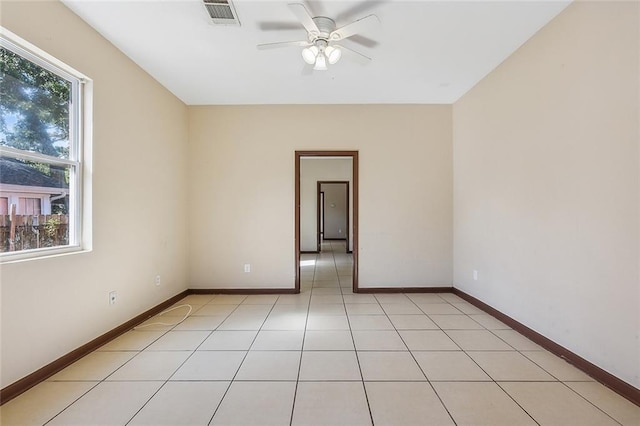 tiled spare room with ceiling fan