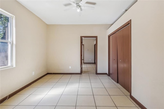 unfurnished bedroom featuring light tile patterned floors, ceiling fan, and a closet