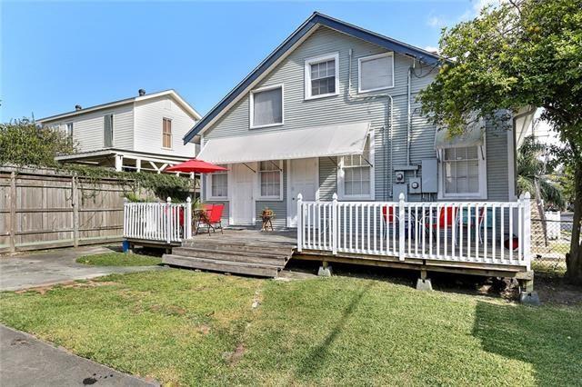 rear view of house featuring a lawn and a deck