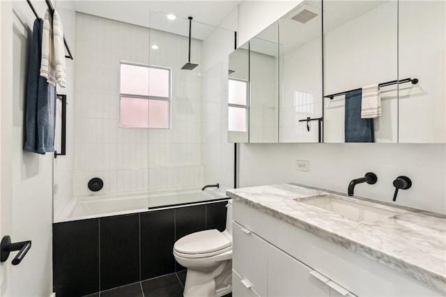 full bathroom with vanity, toilet, and tiled shower / bath combo