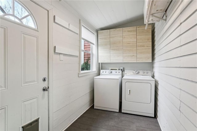 washroom with cabinets, wood-type flooring, washer and dryer, and wood walls