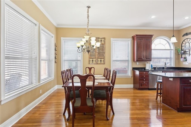 dining space with wood-type flooring, ornamental molding, and a chandelier