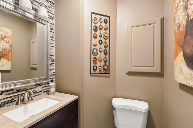 bathroom featuring tasteful backsplash, vanity, and toilet