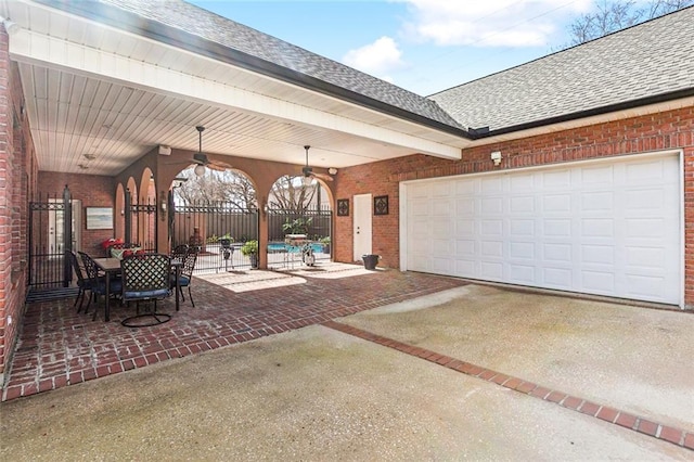 view of patio / terrace with a garage and ceiling fan