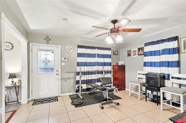 exercise area featuring ceiling fan and light tile patterned floors