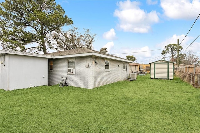 back of house with cooling unit, a lawn, central air condition unit, and a storage unit