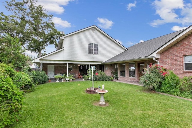 330 Saint Nicholas St, Luling, LA 70070 - back of house with a shingled roof, a patio, brick siding, and a lawn