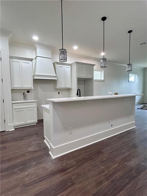 kitchen featuring a center island, custom exhaust hood, and hanging light fixtures