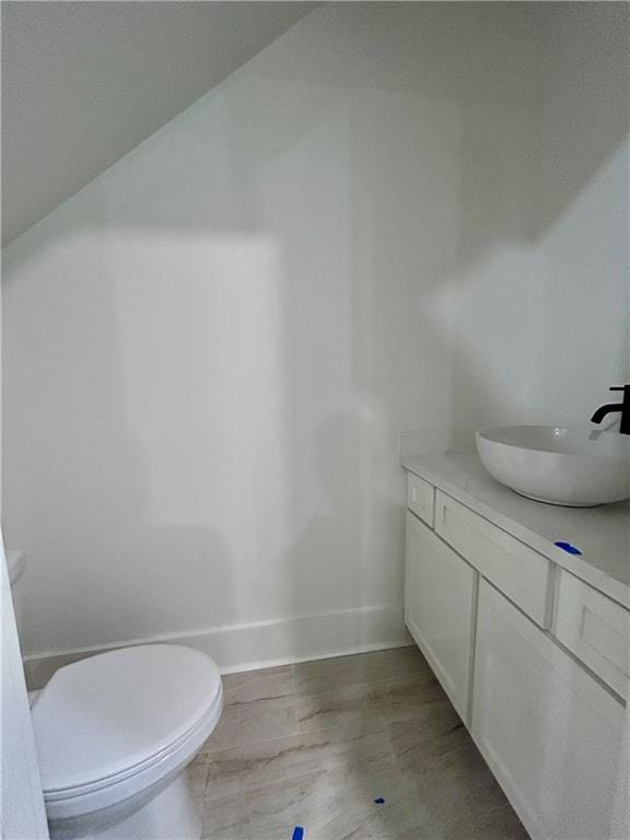 bathroom featuring vanity, hardwood / wood-style floors, and toilet