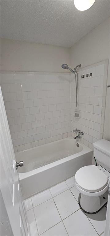 bathroom featuring tile patterned flooring, tiled shower / bath combo, a textured ceiling, and toilet