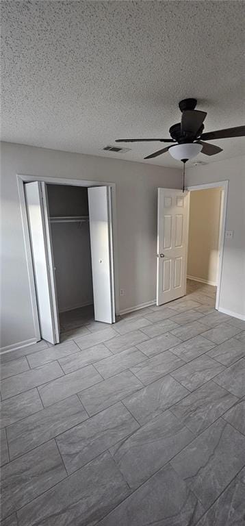 unfurnished bedroom featuring a textured ceiling, a closet, and ceiling fan