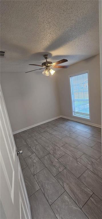 empty room featuring a textured ceiling and ceiling fan