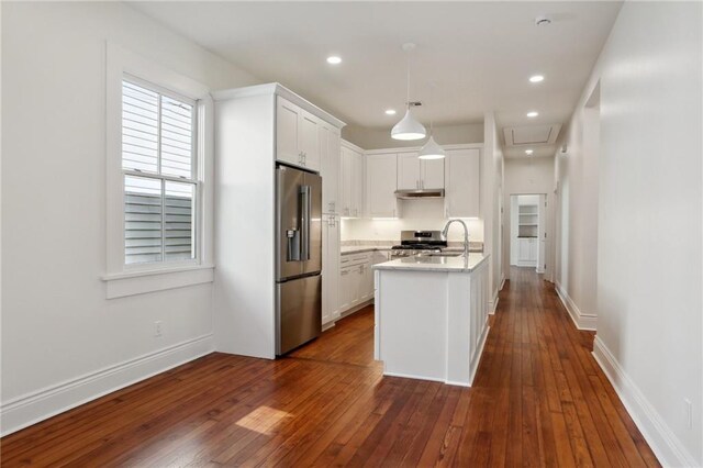 kitchen with dark hardwood / wood-style floors, decorative light fixtures, white cabinetry, sink, and stainless steel appliances