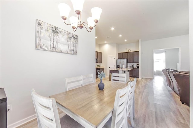 dining area featuring a chandelier and light wood-type flooring