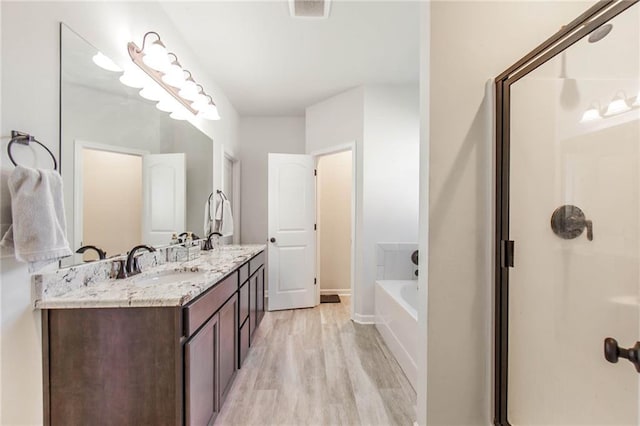 bathroom with vanity, hardwood / wood-style floors, and shower with separate bathtub