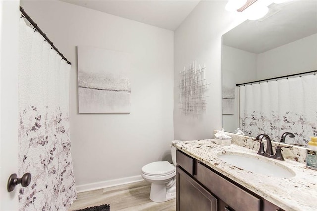 bathroom featuring vanity, toilet, and hardwood / wood-style floors