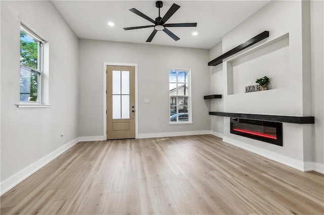 unfurnished living room with light hardwood / wood-style floors and ceiling fan