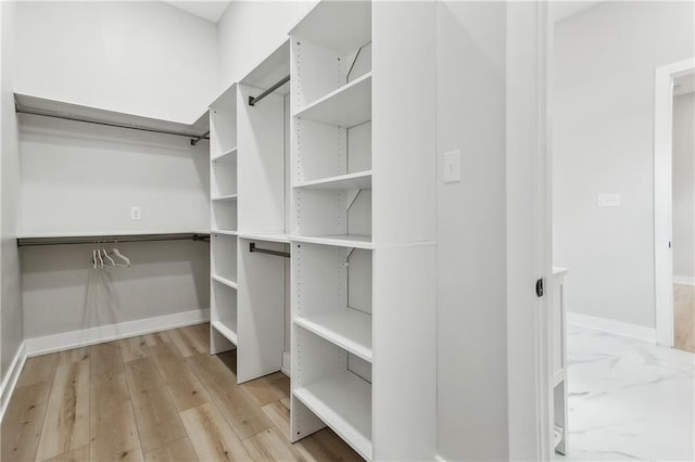 spacious closet with light hardwood / wood-style flooring