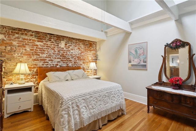 bedroom with hardwood / wood-style flooring, brick wall, and beamed ceiling