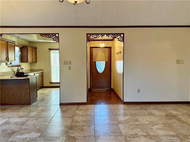 kitchen featuring stainless steel dishwasher, a textured ceiling, and light tile patterned floors