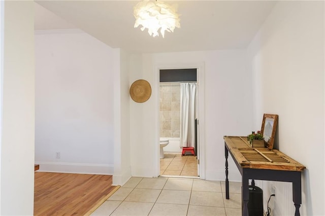 hall with light tile patterned floors and a chandelier