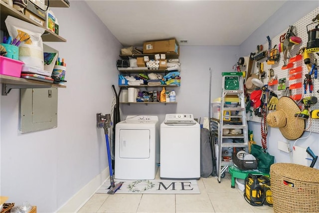 laundry room with light tile patterned flooring, electric panel, and separate washer and dryer