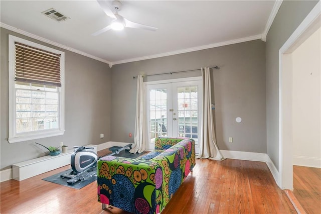 bedroom with crown molding, ceiling fan, access to exterior, wood-type flooring, and french doors