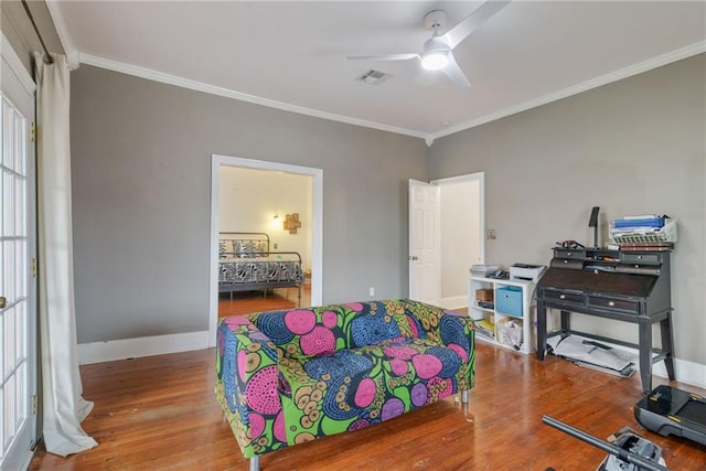 bedroom with crown molding, hardwood / wood-style floors, and ceiling fan