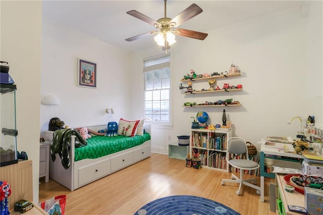 bedroom with radiator, hardwood / wood-style floors, and ceiling fan