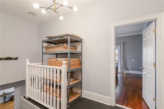 bedroom featuring dark hardwood / wood-style flooring, ornamental molding, and an inviting chandelier