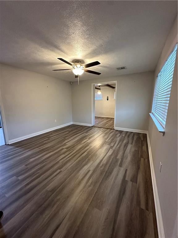 unfurnished bedroom featuring ceiling fan, dark hardwood / wood-style flooring, and a textured ceiling