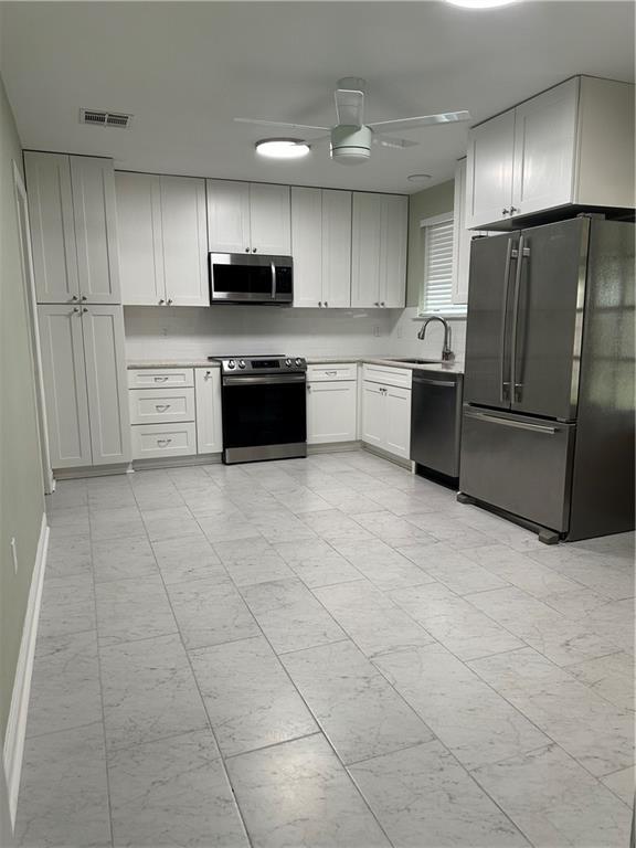 unfurnished bedroom featuring dark hardwood / wood-style flooring, connected bathroom, a textured ceiling, and ceiling fan