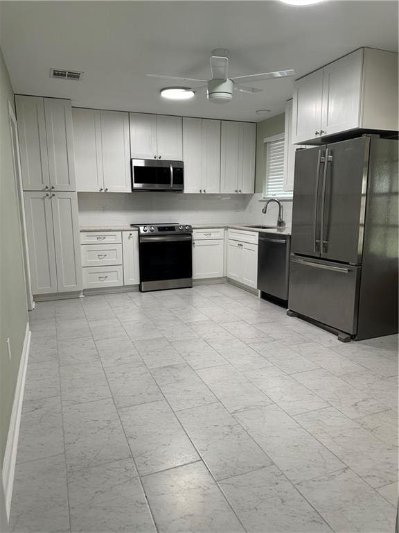 kitchen with visible vents, a ceiling fan, stainless steel appliances, light countertops, and a sink