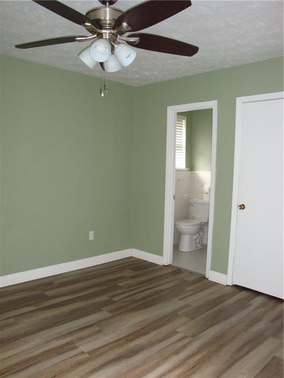 empty room with hardwood / wood-style floors and a textured ceiling