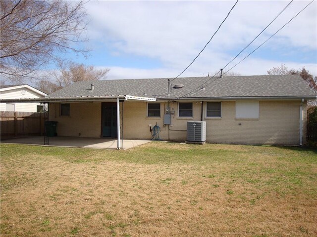 rear view of property featuring a yard, a patio, and central air condition unit