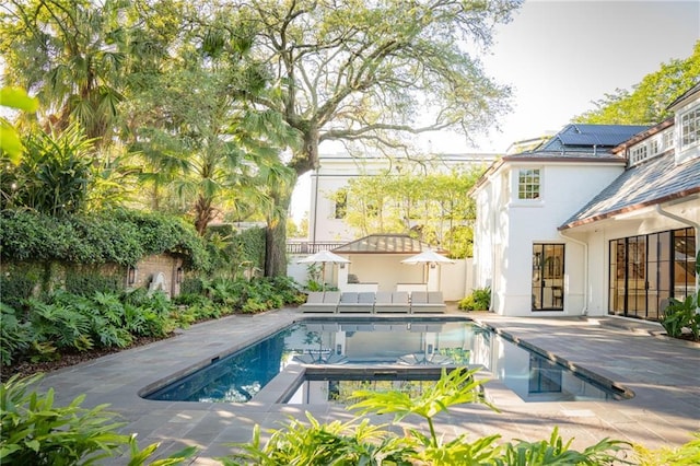 view of swimming pool featuring a hot tub and a patio