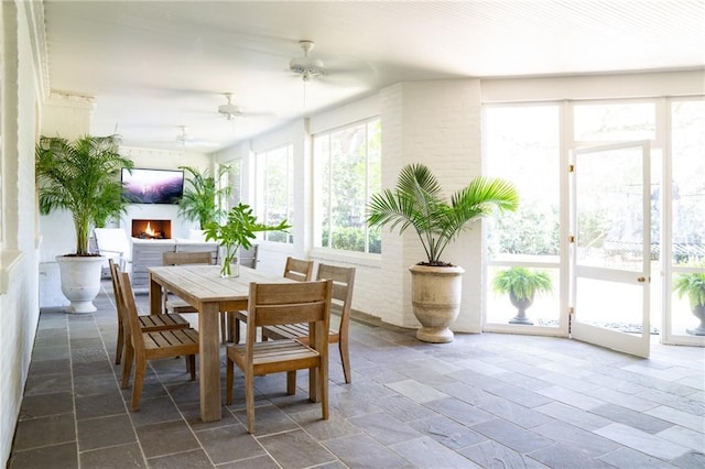 sunroom / solarium featuring a healthy amount of sunlight and ceiling fan