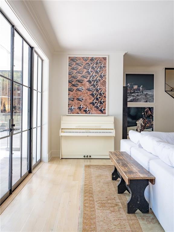 living room with crown molding and light wood-type flooring