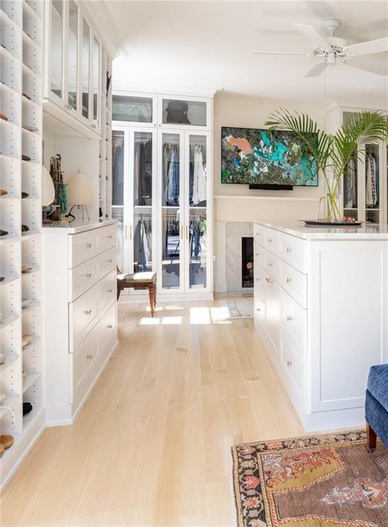 spacious closet featuring ceiling fan and light hardwood / wood-style floors