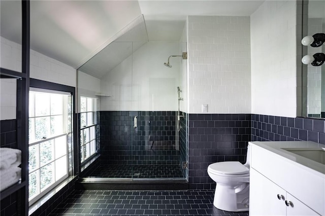 bathroom with vanity, an enclosed shower, tile walls, and a wealth of natural light