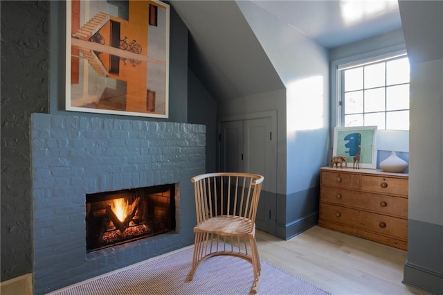 sitting room with lofted ceiling and light wood-type flooring