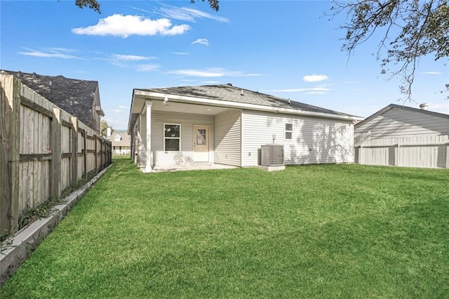 back of property with a lawn and central air condition unit