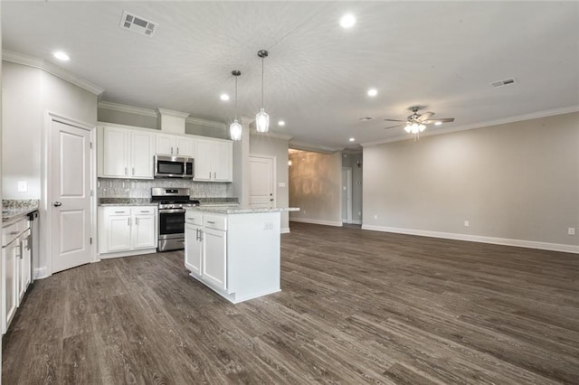 kitchen with stainless steel appliances, a center island, white cabinets, and decorative light fixtures