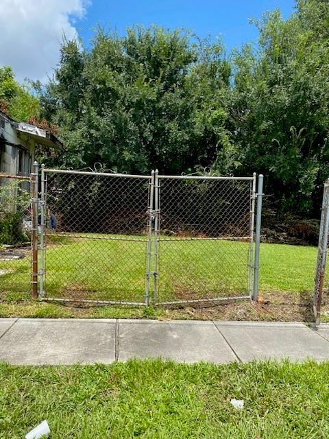 view of gate with a lawn