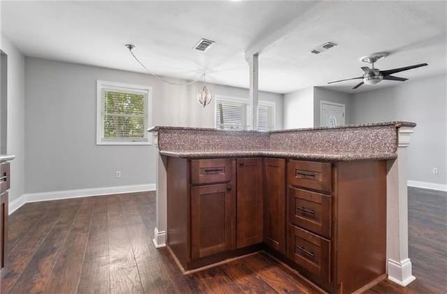 kitchen featuring a center island, dark hardwood / wood-style floors, ceiling fan, and decorative light fixtures