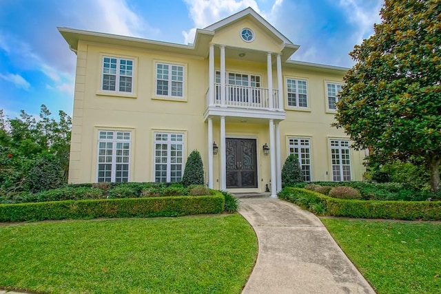 neoclassical / greek revival house with a front yard and a balcony