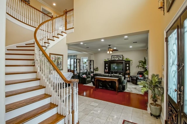 stairway with a high ceiling, tile patterned floors, and ceiling fan