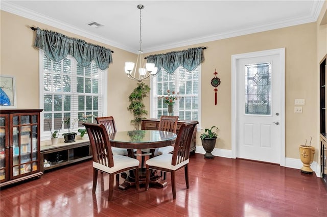 dining area featuring dark hardwood / wood-style flooring, crown molding, and a chandelier