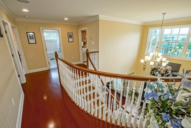 hallway featuring an inviting chandelier, a healthy amount of sunlight, and crown molding